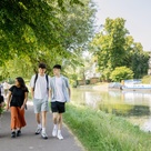 A group of University of Cambridge students spending time with friends and walking in a park by the river in central Cambridge