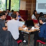 Participants at ICCS Summer School, sitting at tables working and chatting together