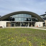 The Centre for Mathematical Sciences in spring, with flowers blooming on the grass outside